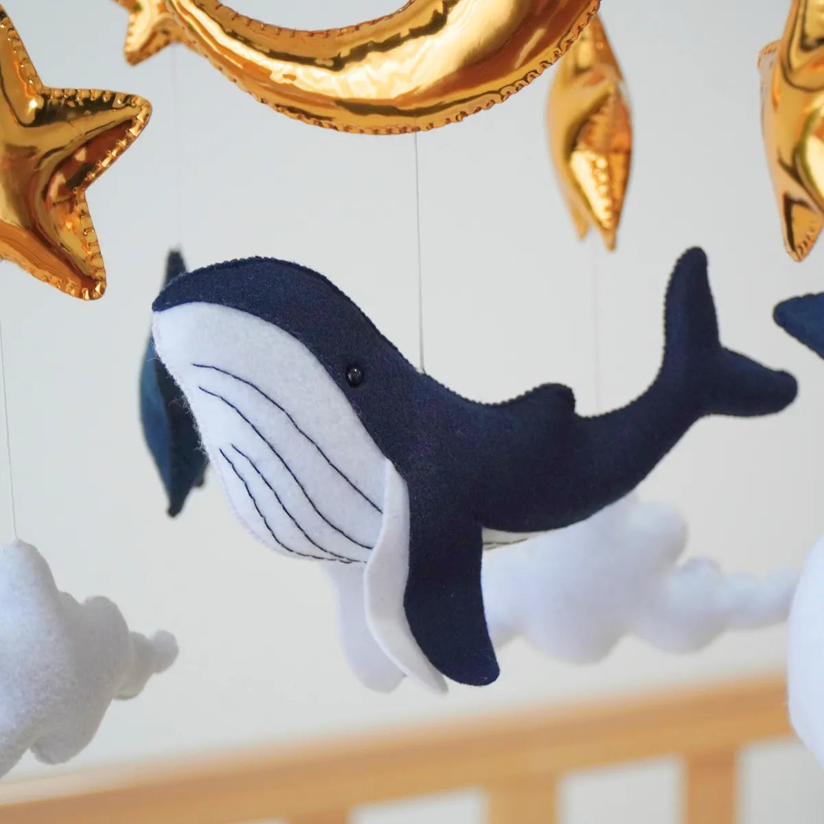 Close-up of the hand-stitched navy felt whale on the Ocean Whale mobile