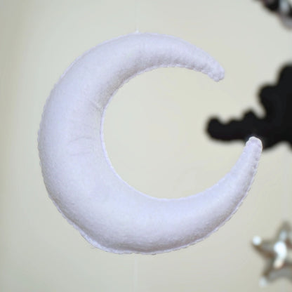 White crescent moon plush hanging from Tinitigies baby crib mobile, nursery decor