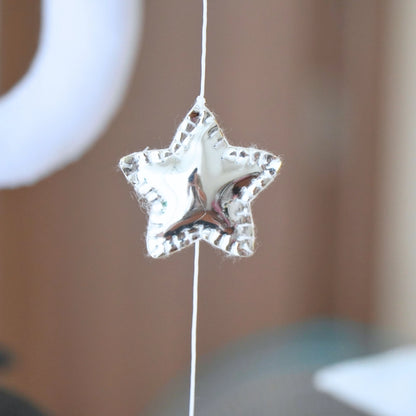 Silver star ornament on Tinitigies baby mobile for nursery crib