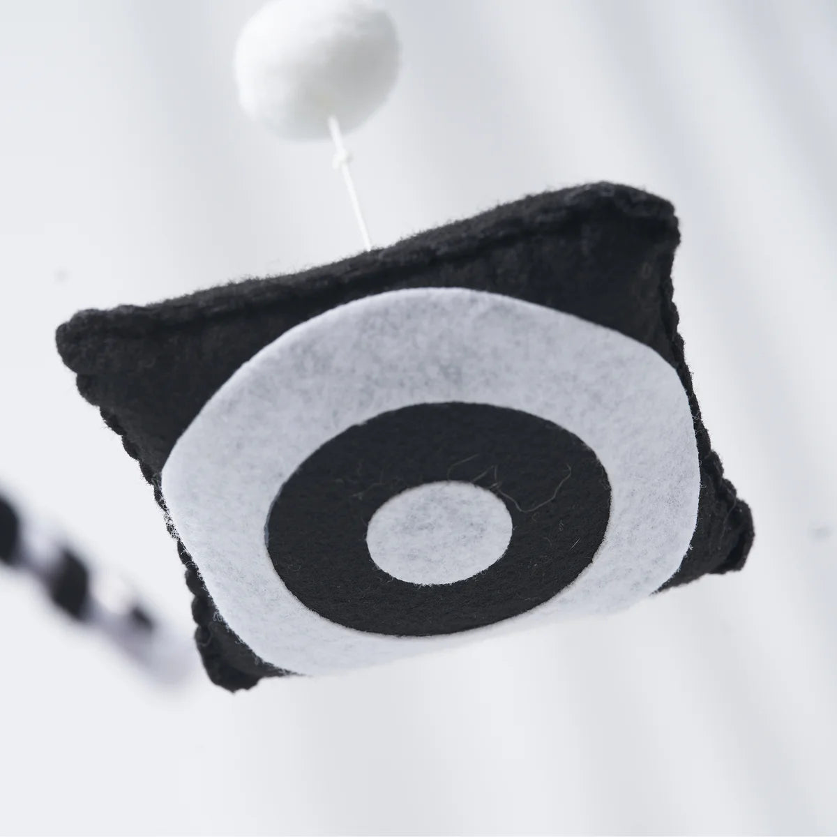 Close-up of the black-and-white circular pattern on a felt hanging shape