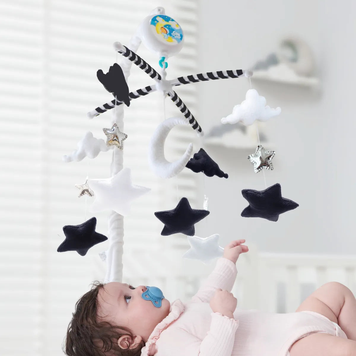 Moon, clouds and stars mobile viewed above a baby’s crib