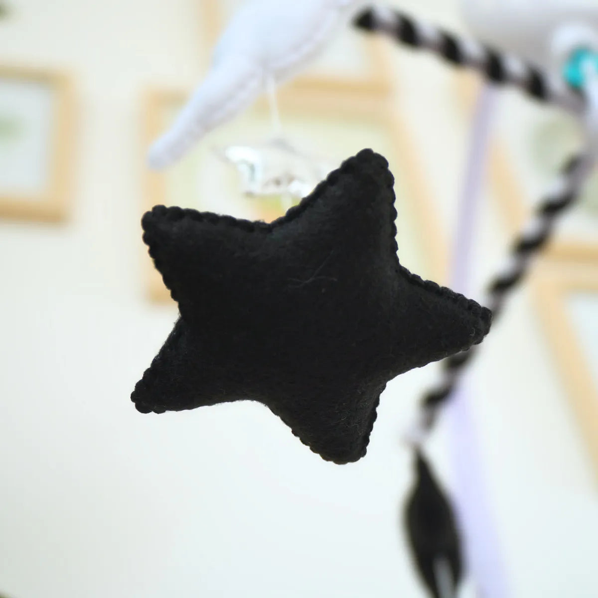 Close-up of a black felt star hanging from the Moon & Stars mobile